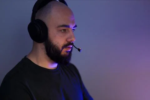 Man in Headset Concentrating on Computer Task Stock-Fotos
