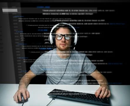 Man in headset hacking computer or programming Stock Photos