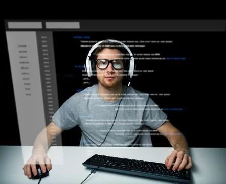 Man in headset hacking computer or programming Stock Photos