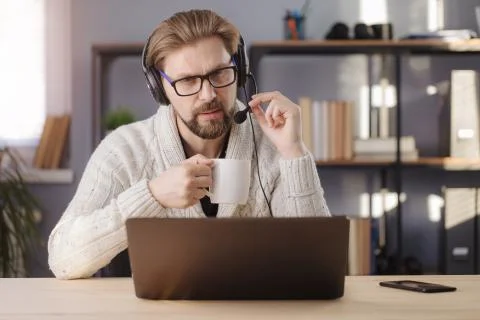 Man in headset having video call while working at home Stock Photos
