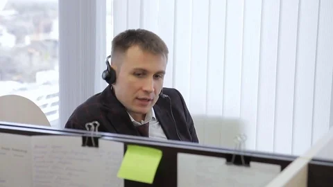 Man in headset on his head is videoconferencing at desk. Stock Footage 85448841