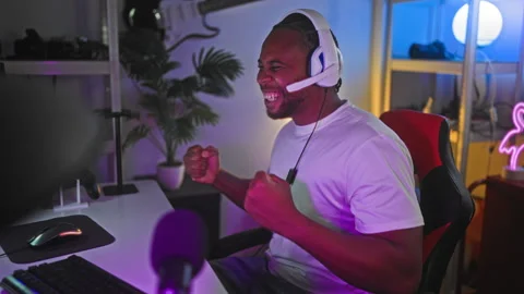 Man with headset pumps fists at computer in studio while smiling and raisin.. Stock Footage 347694747