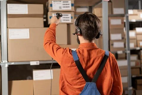 Man in headset uses a barcode reader in a distribution warehouse Stock Photos