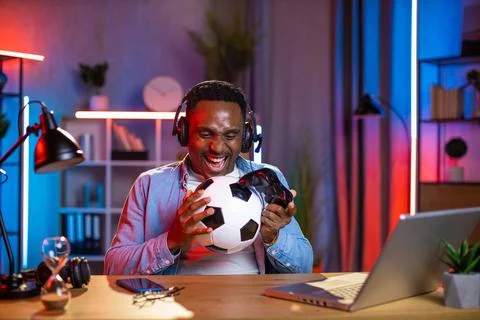Man in headset using joystick and laptop for playing games Foto stock
