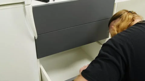 Man with hearing aid provides moving of drawer observing process Stock Footage 316189780