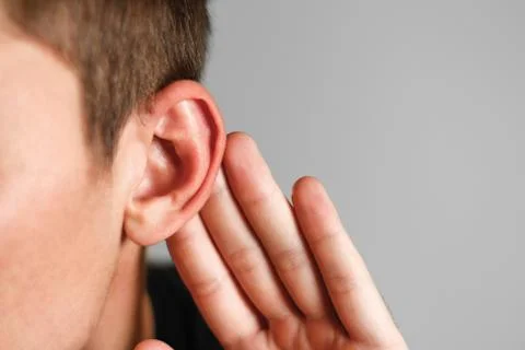 Man with hearing problem on grey background. Close up Stock-Fotos