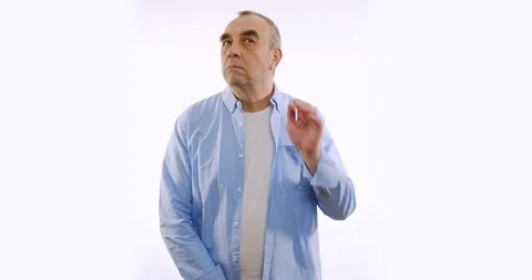 Man with hearing problems holding hand near his ear and listening around Stock Footage 128834834