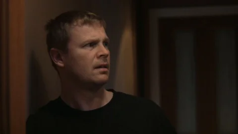 A man hears something in a hallway. Stock Footage 99608835