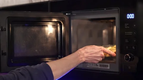 Man heating up food in the microwave Stock Footage 234821164