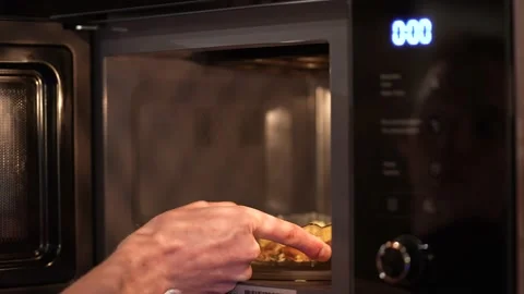 Man heating up food in the microwave Stock Footage 234821166