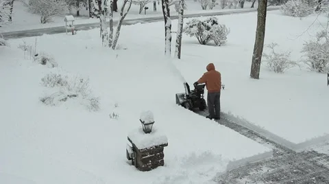 Man in heavy coat plows down driveway Stock Footage 58026792