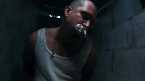 Man held captive in dark concrete corridor Stock Footage 325729009