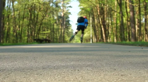 Man with helmet and backpack skates in the park Stock Footage 63357587
