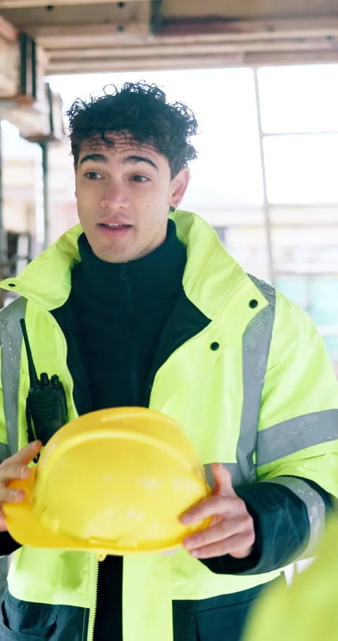 Man, helmet and conversation on construction site for team, compliance or Stock Footage 340893672