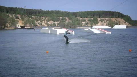 Man in helmet and vest performs tricks on water board Stock Footage 197097993