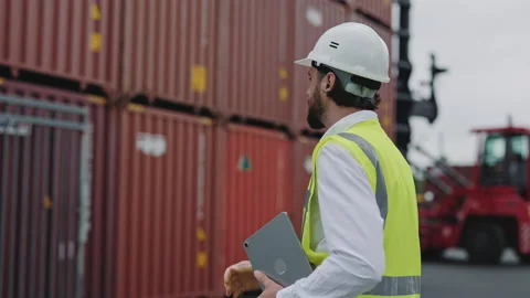 Man in helmet and vest using tablet at cargo harbor Stock Footage 167097106