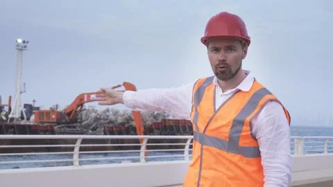 Man in a helmet, architect, engineer, manager tells about course of repair work Fotos Stock