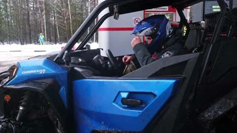 The man in the helmet gets into the UTV off-road vehicle, close the door Stock Footage 188567553