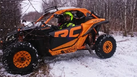 A man in a helmet makes a U-turn on a buggy on a snowy road Stock Footage 177459461