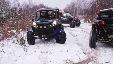 A man in a helmet makes a U-turn on a UTV off-road vehicle buggy on a snowy road Stock Footage 188552713