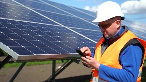 Man in helmet using smartphone on the background of solar panels. Stock Footage 168178557