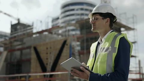 Man in helmet working on tablet at construction plan Stock Footage 167025041