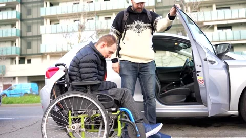 Man helping disabled friend get in car Stock Footage 301686833