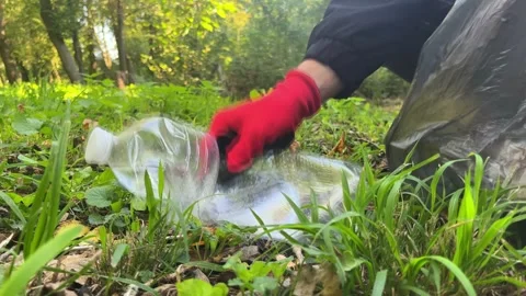 Man helping environment by collecting trash outdoors 動画素材 329319884