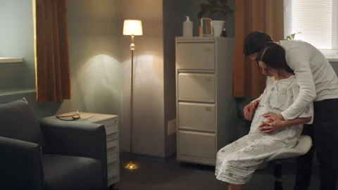Man helping his wife while she is in pain right before childbirth Stock Footage 283068772