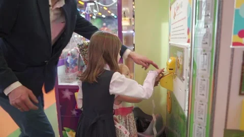 A man helps children to insert coupons into a slot machine. 库存影片 144732383
