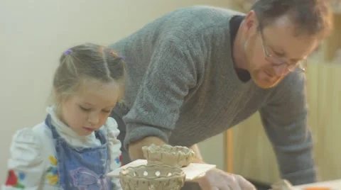 Man Helps The Little Girl to Make a Clay Figurine Man Inclines Upon a Girl Kid Stock Footage 59135356