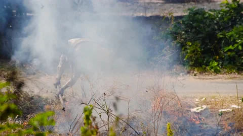 Man hidden from view by thick black white sooty smoke Stock Footage 142818363