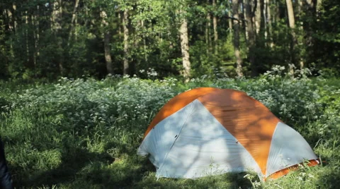 Man hides backpack into the tent. The approach puts a backpack and a tent closes Stock Footage 64326565