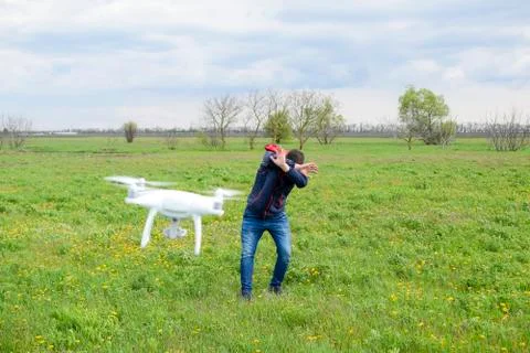 A man hides himself from a collision with a drone. Quadrocopter flies to th.. Stock-Fotos