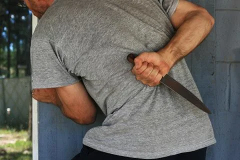 Man hides knife Stock Photos