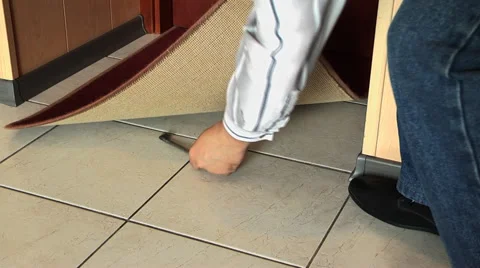 Man is hiding a house key under the mat Stock Footage 50438470