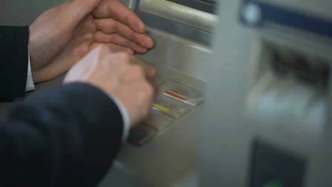 Man hiding keyboard of automated teller machine while inserting his pin code Stock Footage 90911586