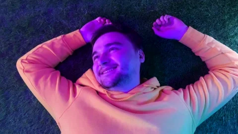 Man high after consuming psychodelics, having good trip with colorful lights Vidéo 188960164