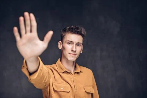 Man with high five gesture on dark background Stock Photos