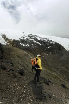 Man hiker with backpack in front of a mountain Stock Photos