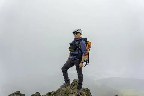 Man hiker with backpack in front of a mountain Stock Photos