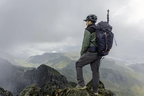 Man hiker with backpack in front of a mountain Stock Photos