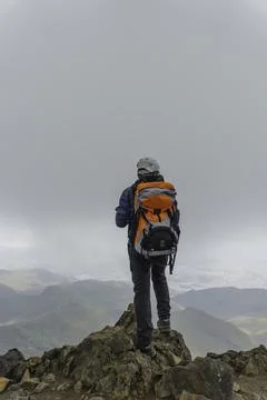 Man hiker with backpack in front of a mountain Stock Photos