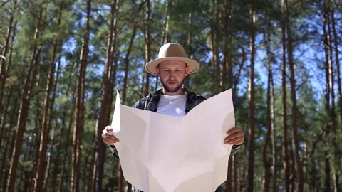 Man hiker consults a map in the forest. Composition hiking. Stock Footage 149945709
