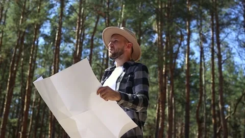 Man hiker consults a map in the forest. Composition hiking. Stock Footage 149945727
