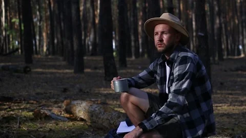 Man hiker drinks tea during a halt in the forest. Concept hike, tourism. Stock Footage 150255510
