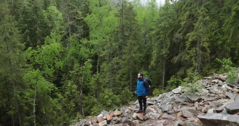A man is a hiker on a hike in a mountain forest walking on rocky 動画素材 243745338