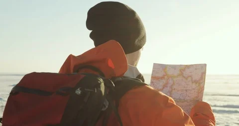 Man hiker is looking at the map in snow mountains checking the route. Winter Stock Footage 106086212
