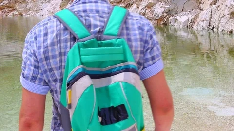 Man hiker refreshing at some large abandoned marble quarry pond Stock Footage 108657987