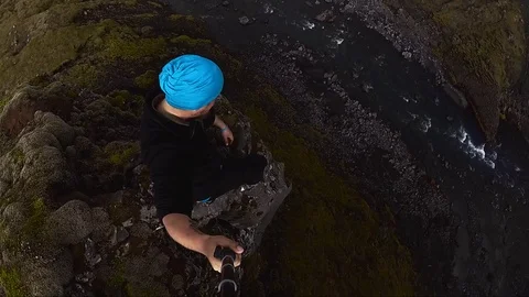 Man hiker sitting above the waterfall Stock Footage 79606325